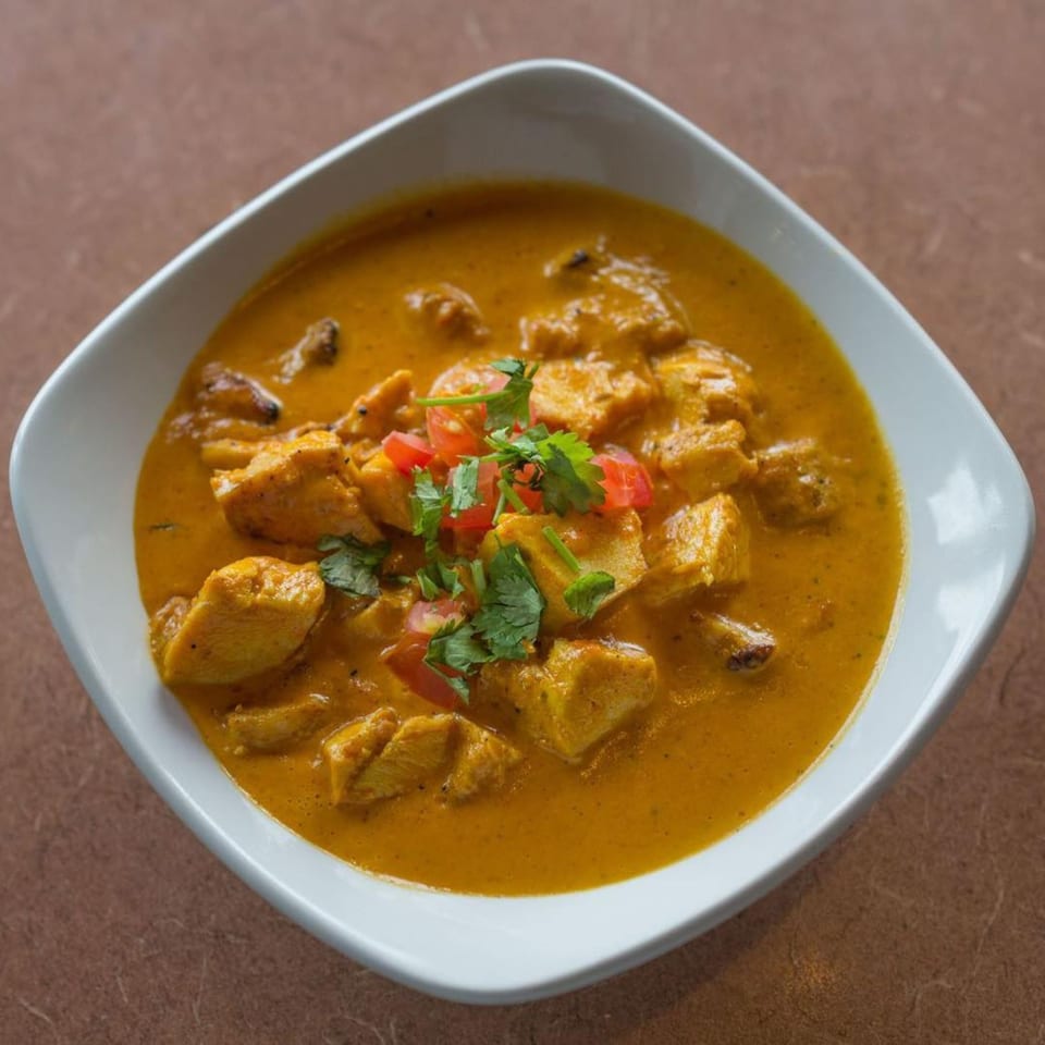 Gorkha Palace Indian Cuisine's chicken curry, garnished with fresh cilantro and diced tomatoes.